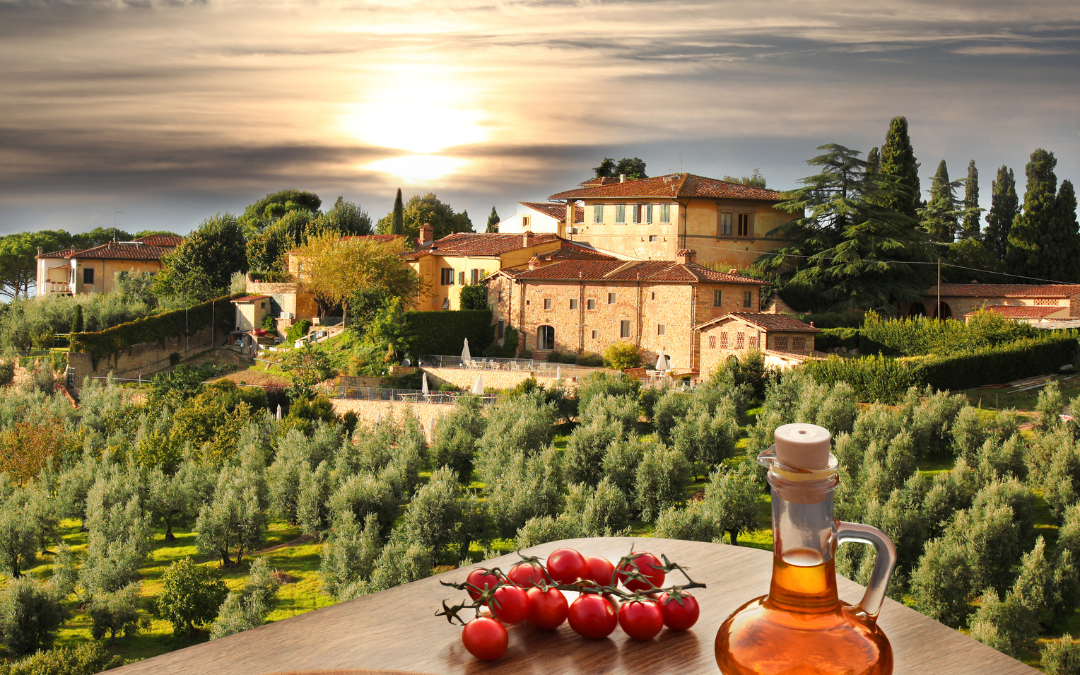 foto de uma paisagem diante de uma mesa com uma pizza, azeite e tomates em cima.